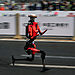 BEIJING, CHINA - APRIL 19: The fastest humanoid robot, an H1made by Honor, runs beside human runners at the start on its way to winning the Beijing Humanoid Half Marathon on April 19, 2026 in Beijing, China. The robot finished with a net time of 50 minutes and 26 seconds. More than 100 humanoid robots from 76 institutions across China lined up alongside 12,000 human runners Sunday in Beijing's E-Town district for the world's largest humanoid robot half-marathon, following the same 21-kilometre course on separate lanes in a 'human-robot co-running' format that for the first time included teams competing under fully autonomous navigation. (Photo by Kevin Frayer/Getty Images)
