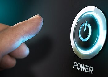 Finger pressing a computer power button representing system boot and firmware security