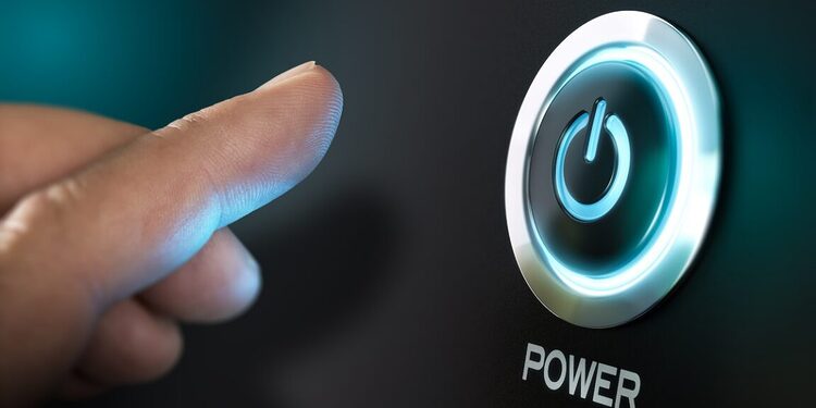 Finger pressing a computer power button representing system boot and firmware security
