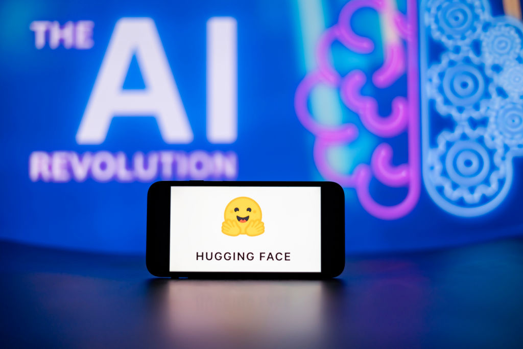 Hugging Face logo on a phone with an AI display in the background